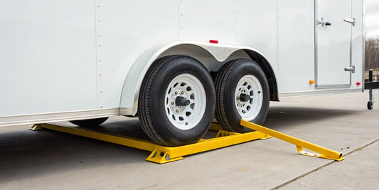 One of the best wheel locks, a heavy-duty yellow clamp, securing a trailer's dual wheels.